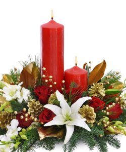 floral centerpiece in greens and reds with 2 red candles