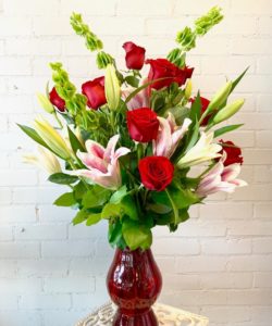 An elegant design for that special someone, filled with a Dozen Red Roses, Stargazer Lilies, and Bells of Ireland.